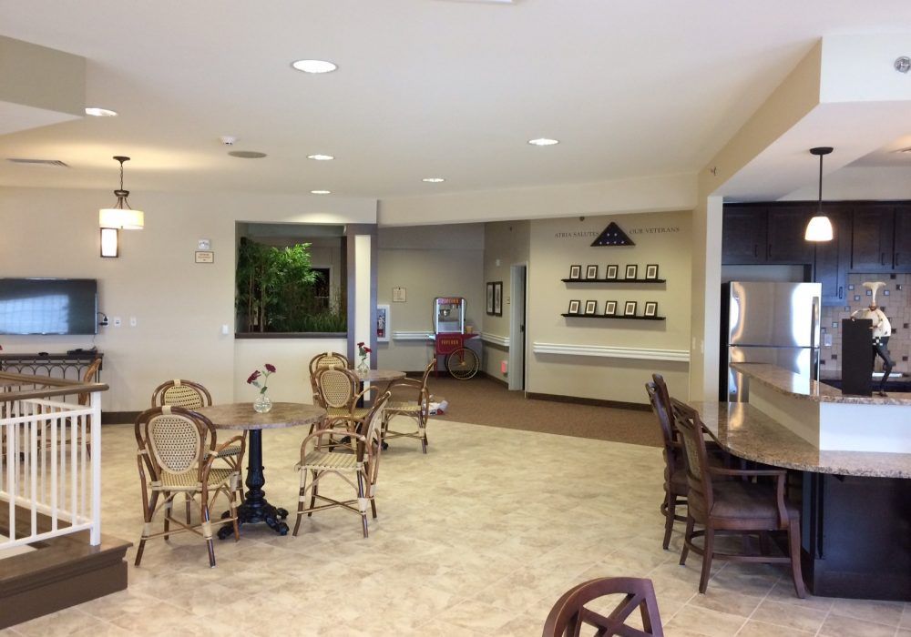 A bright community seating area with tables and chairs arranged in a cafe style.