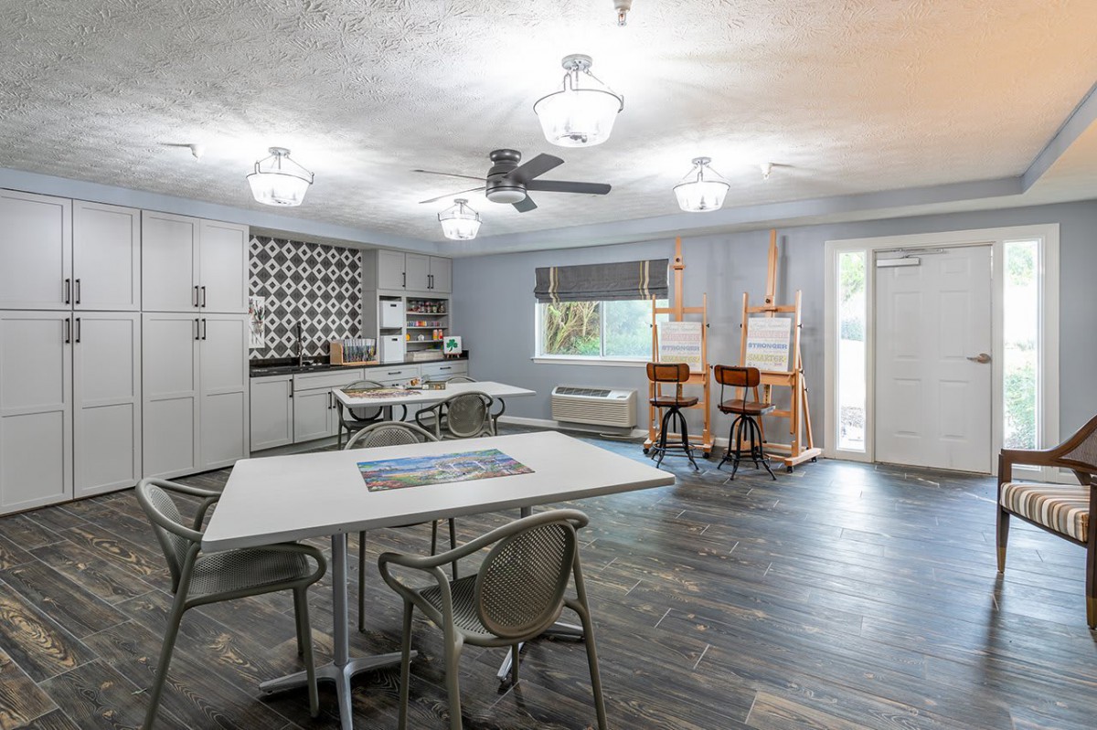 A modern kitchen and dining area with art easels and stylish lighting.