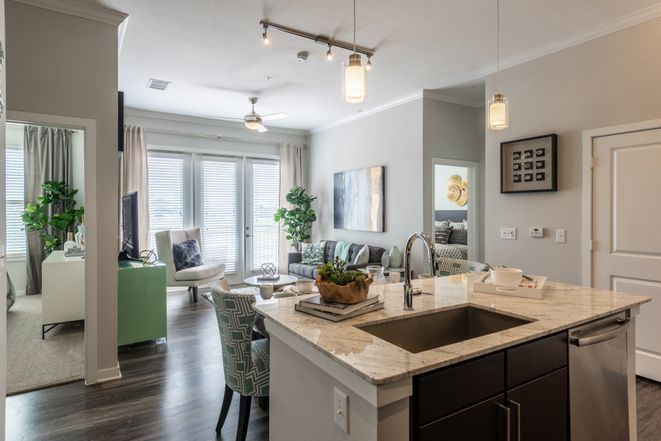A modern open-concept kitchen and living room with elegant decor and soft lighting.