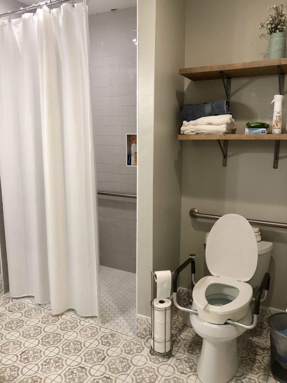 Modern bathroom with a shower, toilet, and shelving.