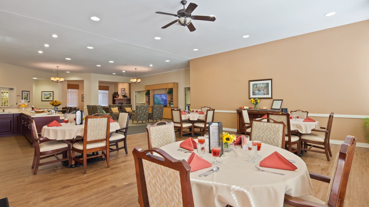 A well-decorated dining room with neatly set tables and comfortable chairs.