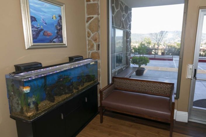 A cozy waiting area with an aquarium and a window view.