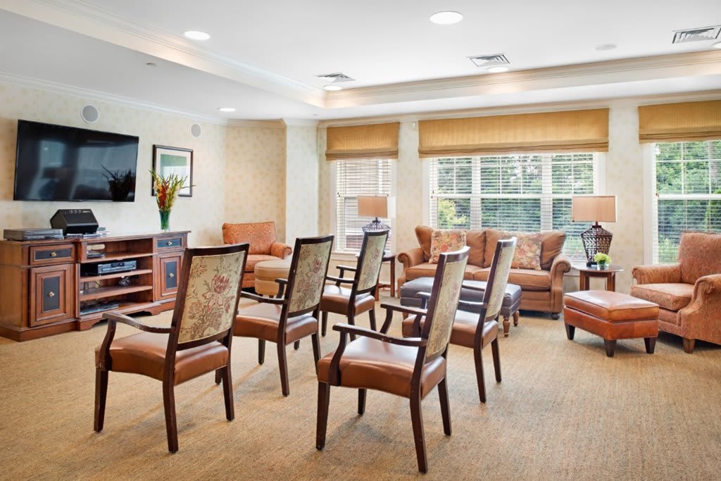 A well-lit living room with chairs arranged for a gathering.