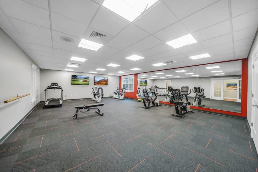A modern fitness center with various exercise equipment, including treadmills and stationary bikes.