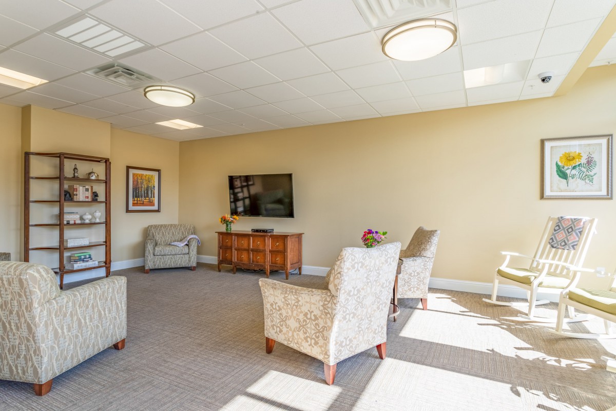 A spacious, well-lit living room with comfortable seating and a television.
