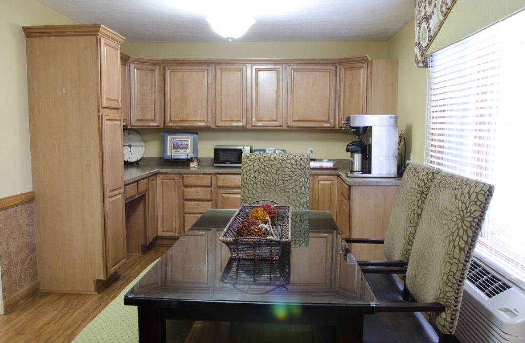 A modern kitchen with wooden cabinets and a dining table.