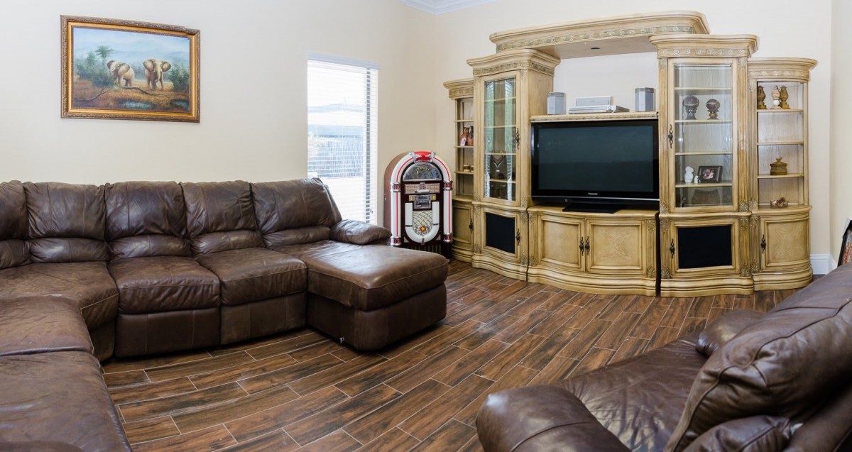 A cozy living room featuring a leather sectional, flat screen TV, and a classic jukebox.