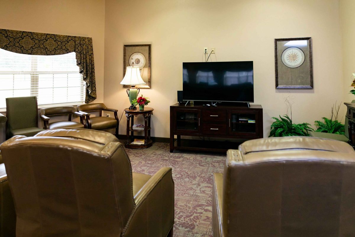 A cozy living room with comfortable seating and a TV entertainment center.
