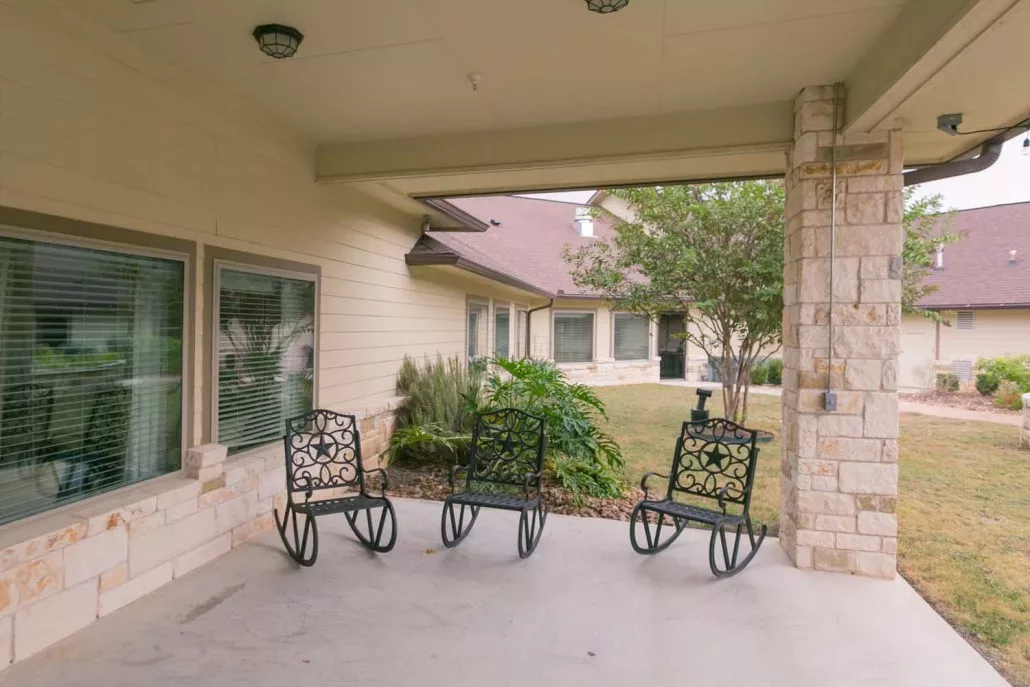 A tranquil patio with rocking chairs overlooking a garden.