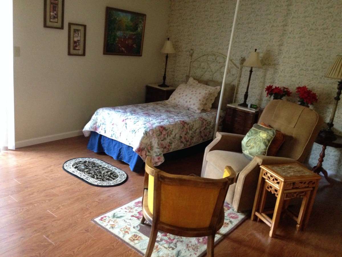 A cozy bedroom with a single bed, chairs, and decorative elements.