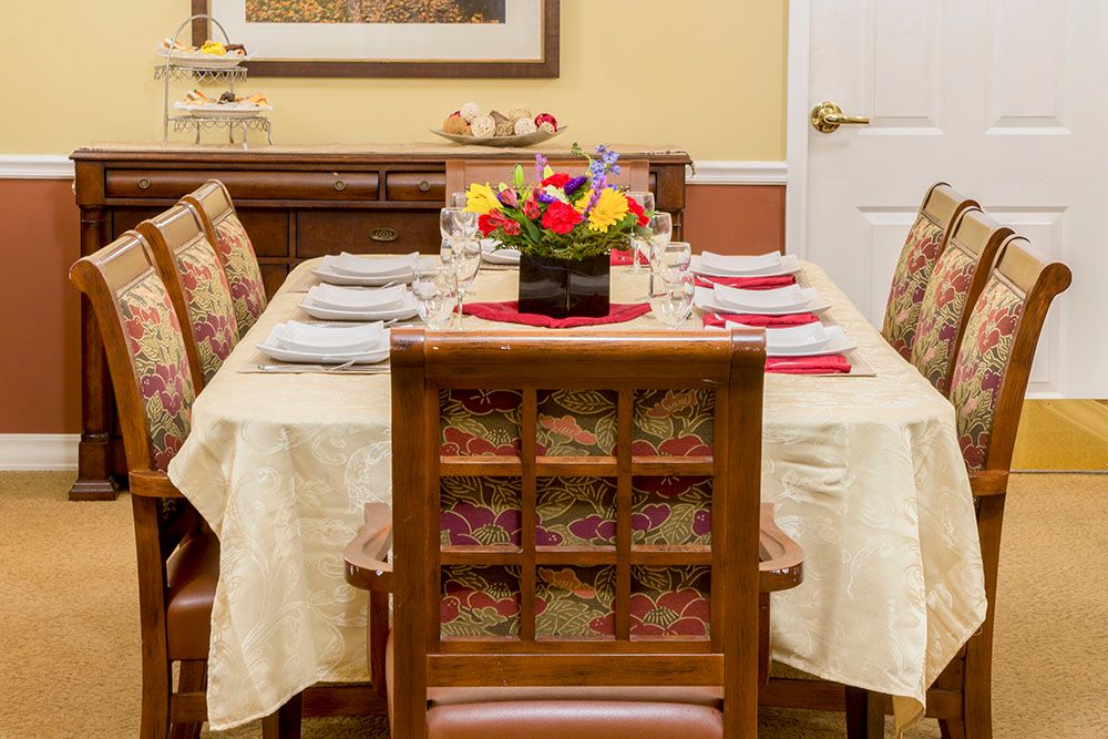 A dining table elegantly set with a floral centerpiece and neatly arranged napkins.