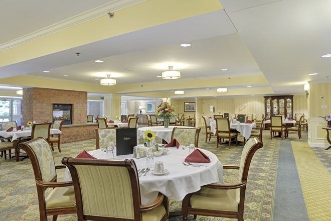 An elegant dining room with neatly set tables and comfortable chairs, ready for guests.