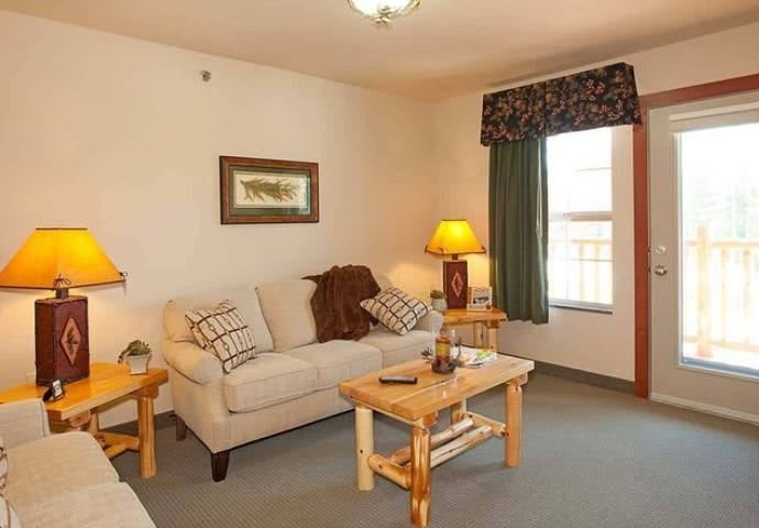 Cozy living room with a sofa, coffee table, and warm lighting.