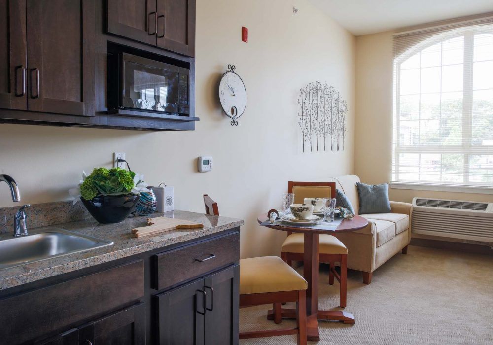 A cozy and compact living space with a kitchenette, seating area, and natural lighting.