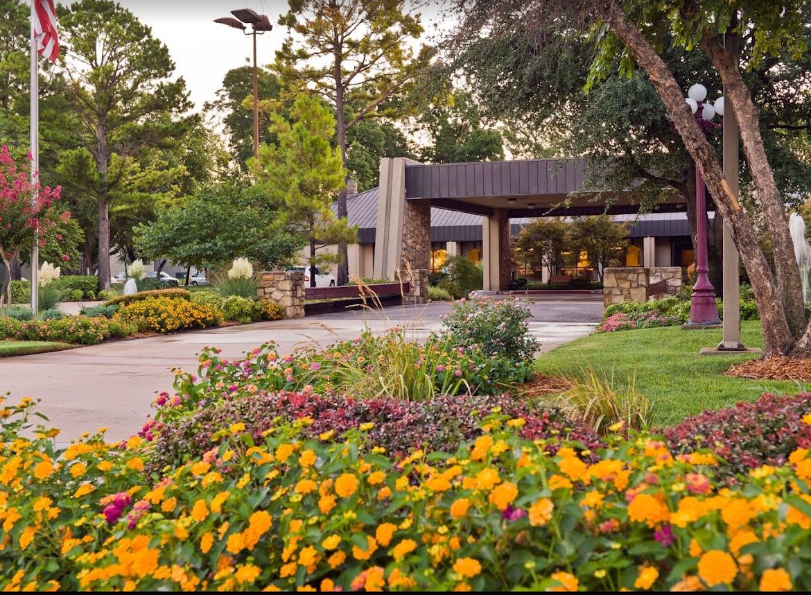 A peaceful garden with colorful flowers in front of a building.