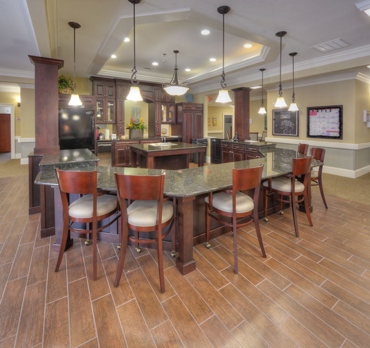 A modern kitchen with stylish bar stools and pendant lighting.