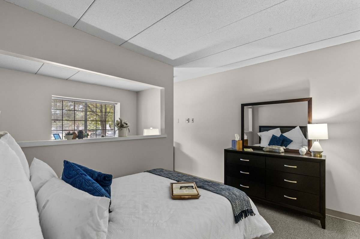 Modern bedroom with a comfortable bed and stylish dresser.