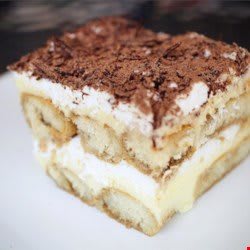 A slice of layered tiramisu with cocoa topping.
