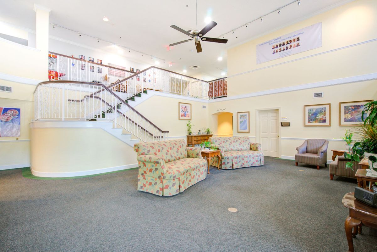 A spacious lobby with a staircase and comfortable seating area.