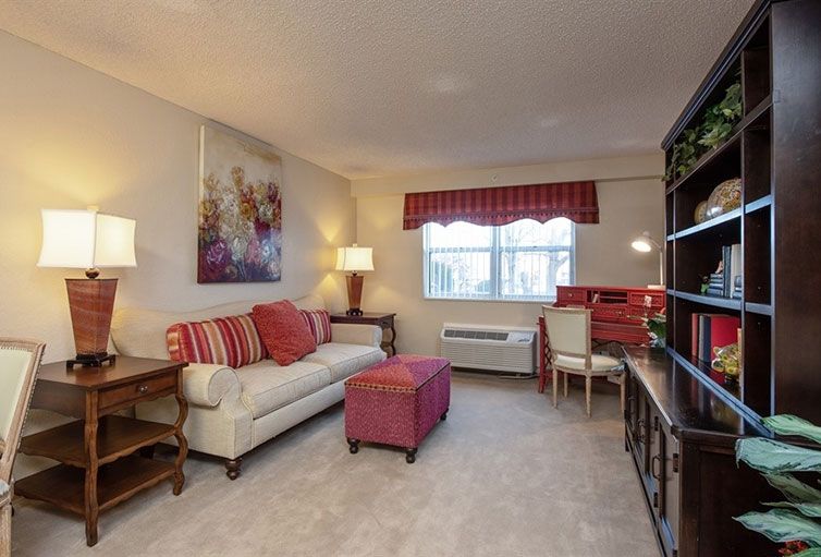 A cozy living room with a sofa, ottoman, and decorative accents in warm tones.