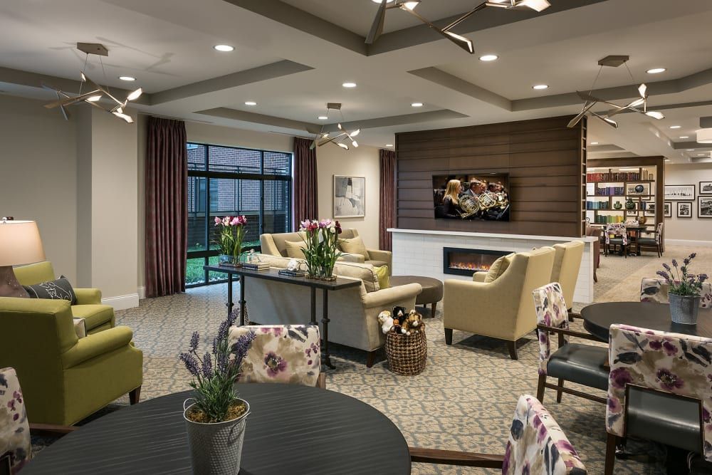 A modern living room with comfortable seating, a fireplace, and large windows overlooking the garden.