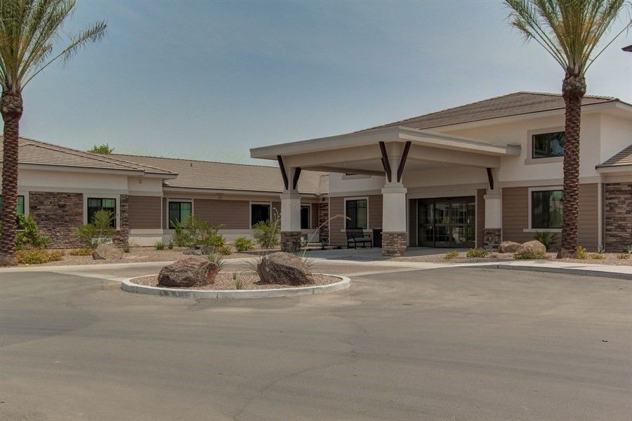 A modern commercial building with a parking lot and landscaped entrance.