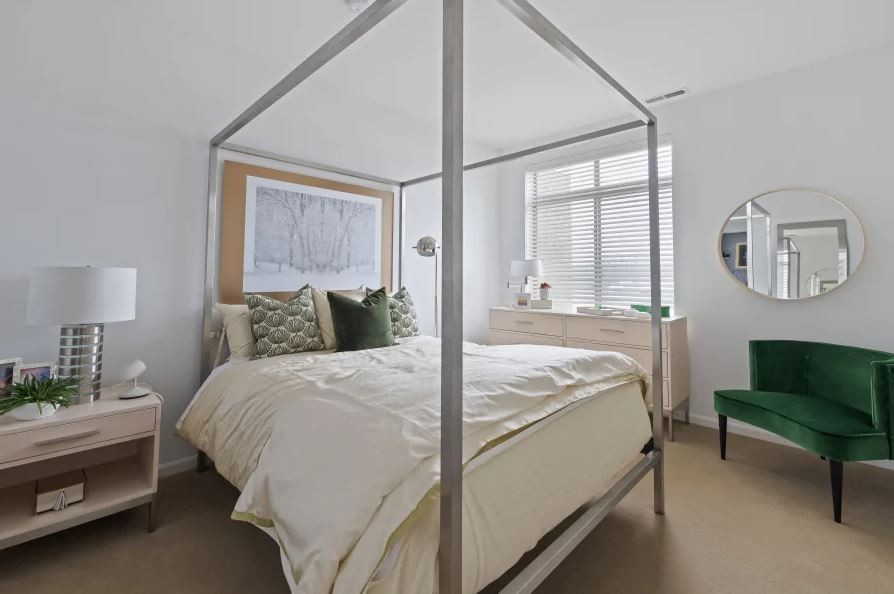 A modern bedroom with a four-poster bed and contemporary decor.