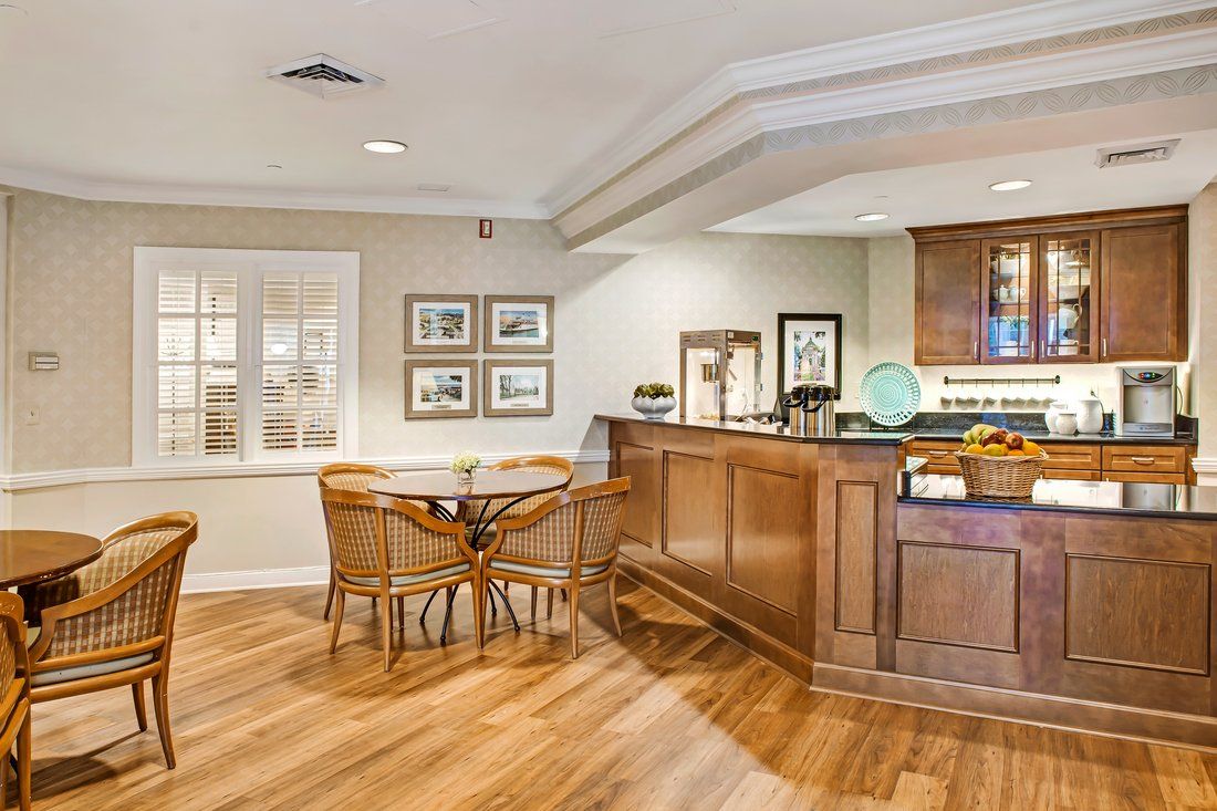 A cozy kitchen interior featuring a wooden bar counter and seating area.