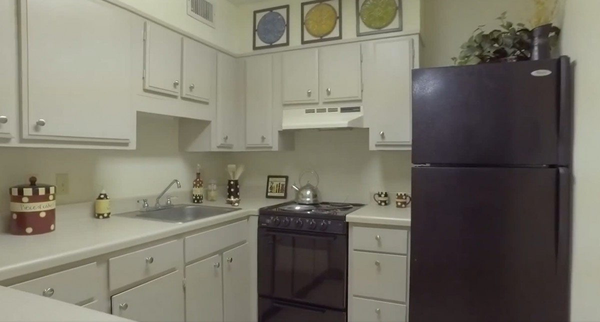 A small kitchen with white cabinets and modern appliances.