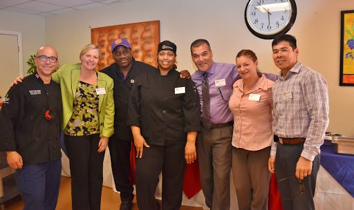 A group of culinary professionals posing together, showcasing teamwork and camaraderie.