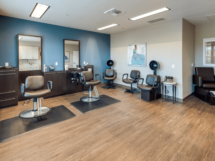 A modern hair salon interior with sleek chairs and mirrors.