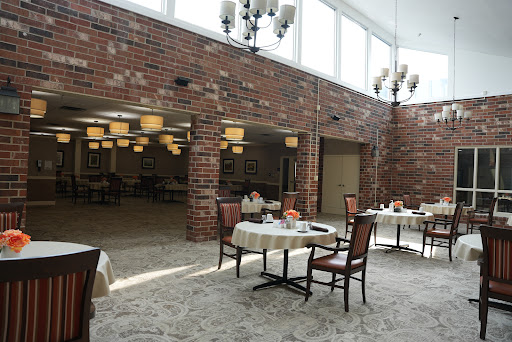 A spacious and inviting dining area featuring elegant chandeliers and a cozy brick wall.