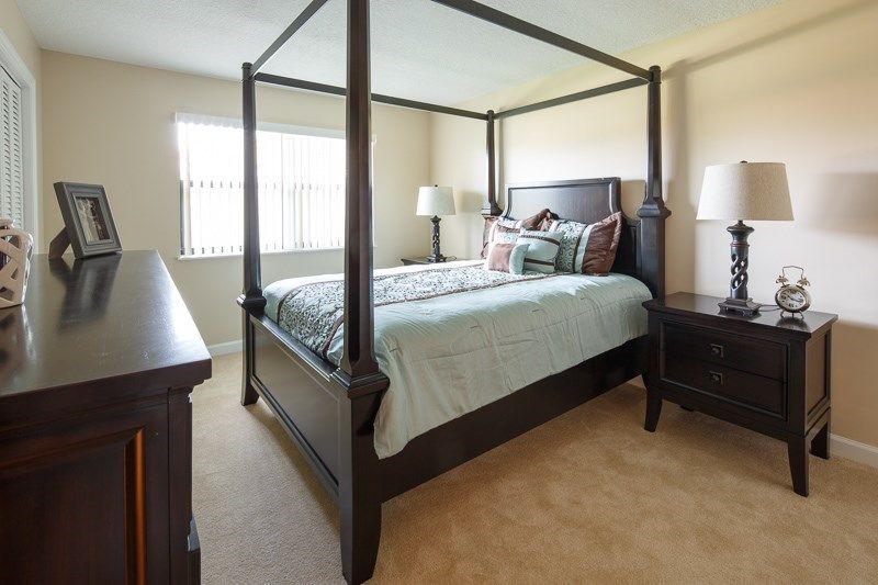 A cozy bedroom featuring a canopy bed, nightstands, and elegant decor.
