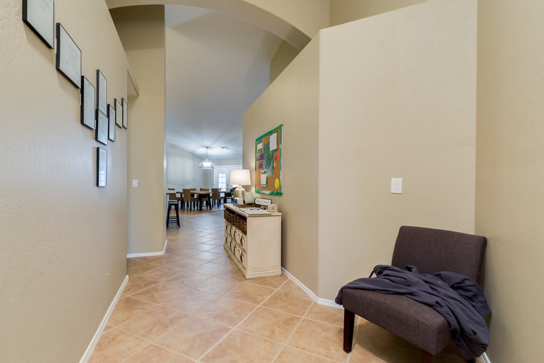 A view of a hallway in a house with tile flooring and modern decor.