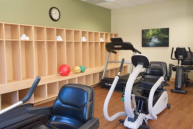 A gym with various exercise equipment and storage shelves.