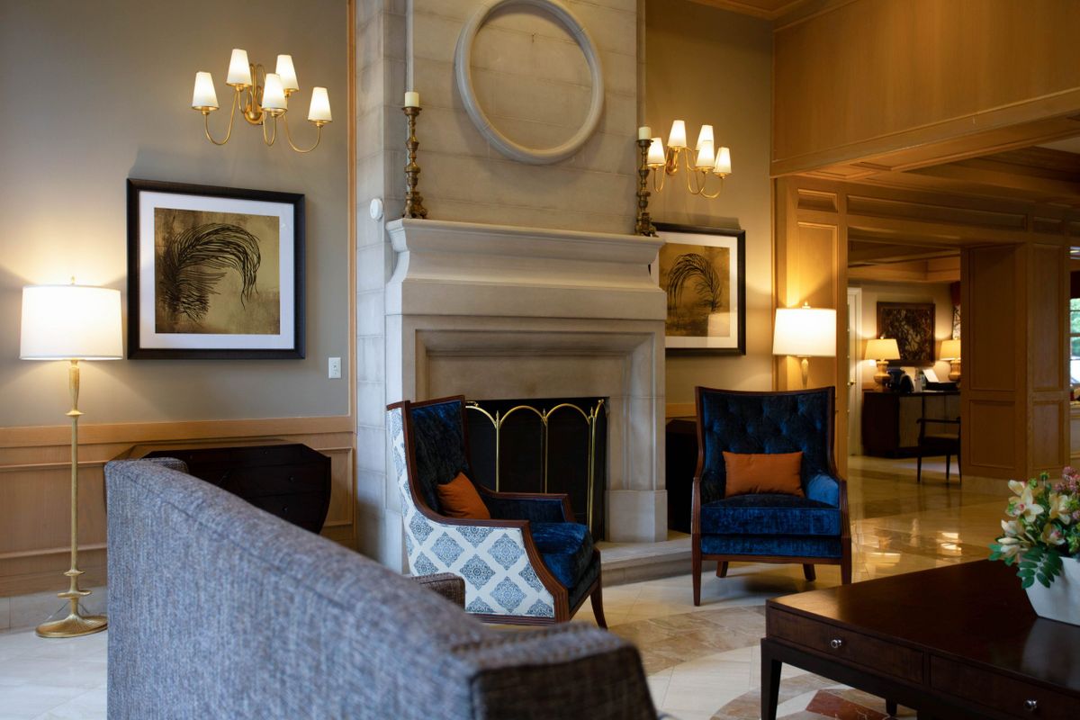 A cozy living room with elegant furniture and a central fireplace.