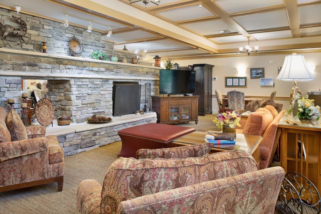 A cozy living room featuring a stone fireplace and comfortable seating.