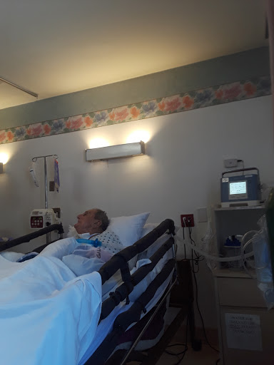 A patient resting in a hospital room with medical monitoring equipment.
