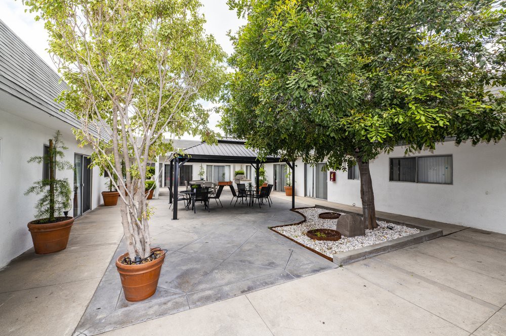 A tranquil outdoor patio area with a gazebo, surrounded by trees and equipped with seating furniture.