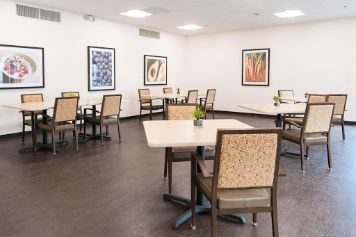 A spacious and modern dining area featuring tables and chairs, adorned with artwork on the walls.