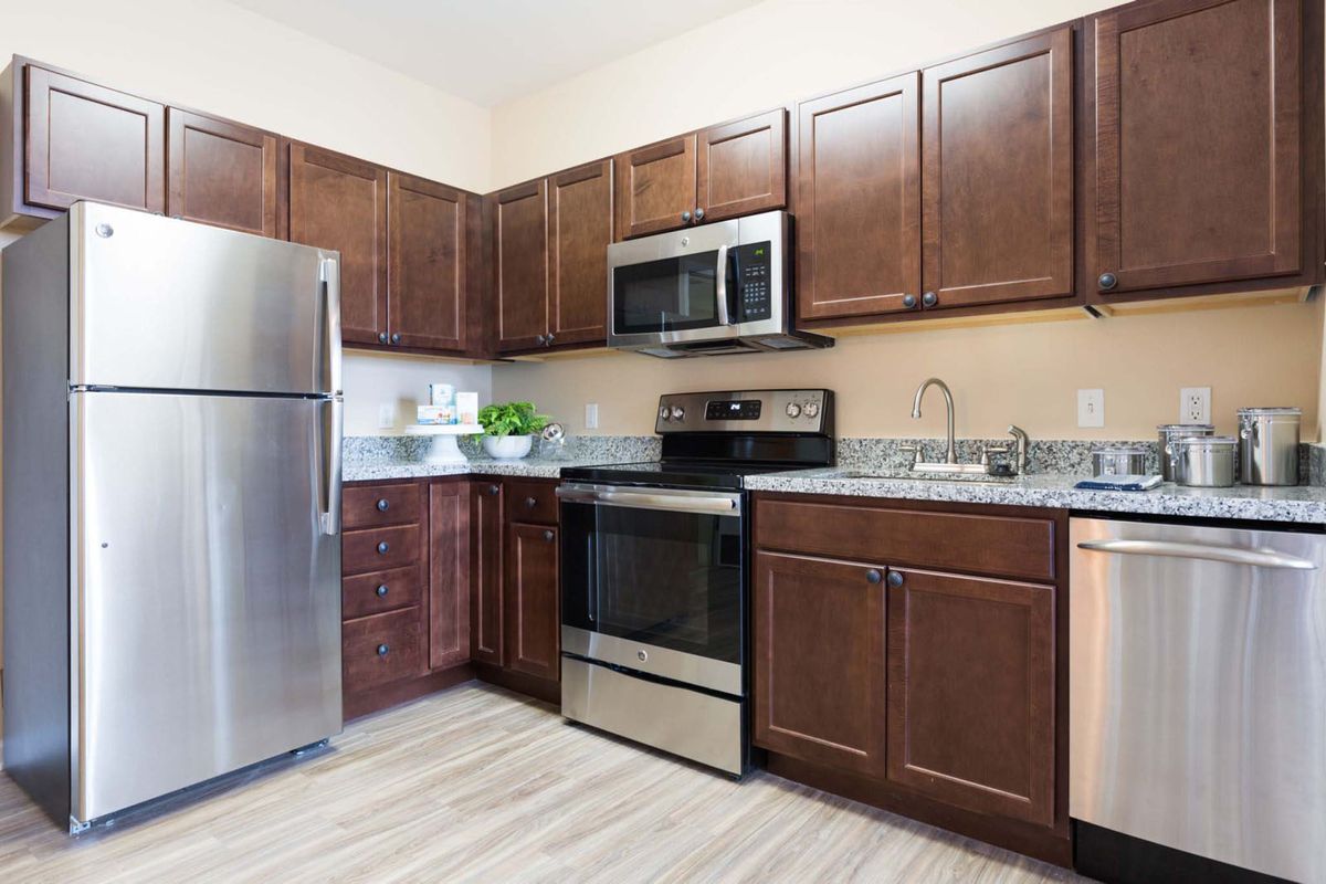 A modern kitchen with stainless steel appliances and dark wood cabinets.
