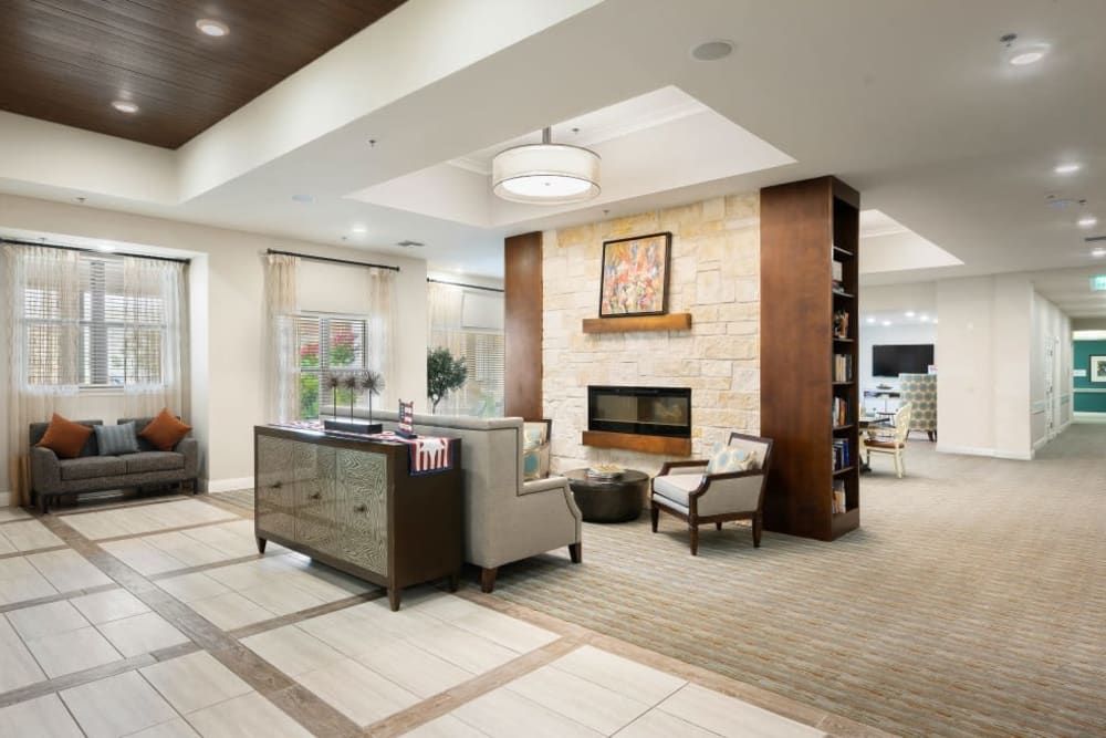 A modern living room with a cozy seating area around a fireplace.