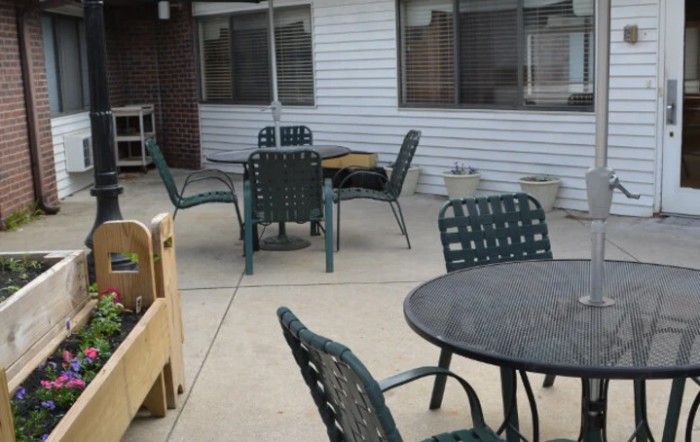 An outdoor patio area with tables and chairs on a concrete surface.