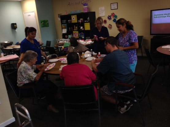 A group of people engaged in a communal activity around a table indoors.