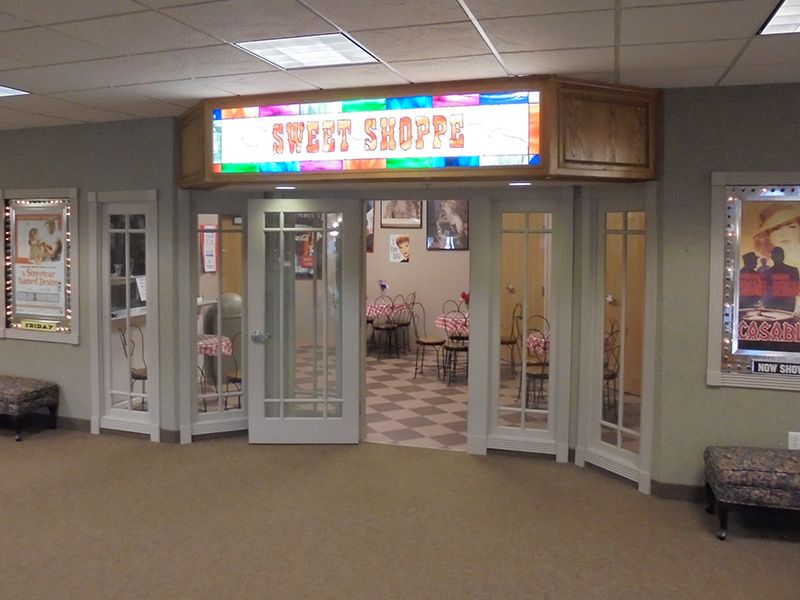 A colorful cafe entrance with glass doors and bright signage.