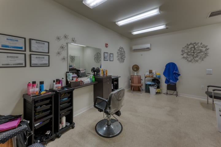 A neatly arranged salon interior featuring a styling chair, mirror, and hair products.