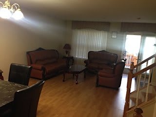 A cozy living room with traditional furniture and wooden flooring.