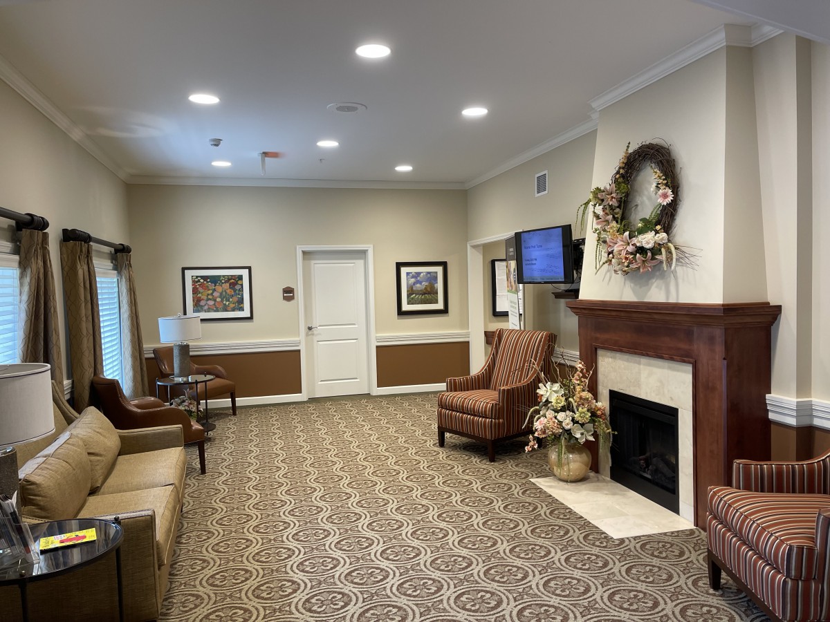 A cozy living room featuring comfortable seating, a fireplace with decorations, and warm lighting.