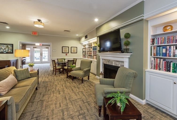 A cozy living room with seating, a fireplace, and a television.