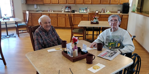 Two elderly friends enjoying breakfast together in a cozy dining area.